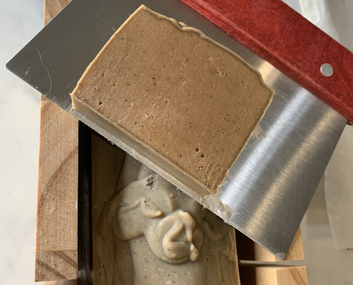 home made Coffee soap block being cut into bars